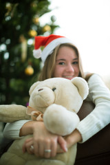 Girl hugs teddy bear in christmas eve