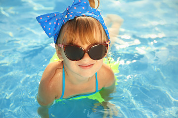 Little girl in swimming pool on sunny day