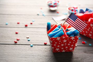 Obraz premium Delicious candies with USA flag in paper box on dark wooden background