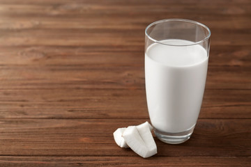 Glass of tasty coconut milk on  wooden table