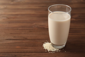 Glass of tasty sesame milk on  wooden table