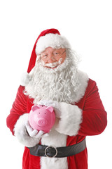 Santa Claus holding piggy bank on white background