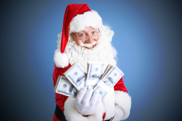 Santa Claus holding money on blue background