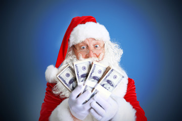 Santa Claus holding money on blue background