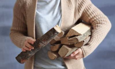 Woman holding pile of firewood, close up view