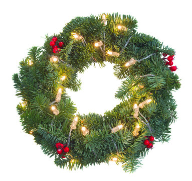 Christmas green wreath with red berries and glowing christmas lights isolated n white background