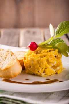 Portion of scrambled eggs with radish and pastry