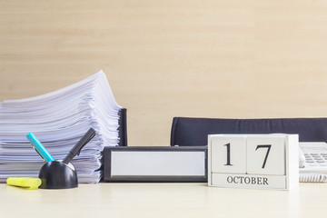 Closeup white wooden calendar with black 17 october word on blurred brown wood desk and wood wall...