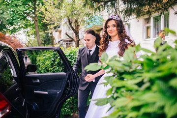 gorgeous wedding couple walking in the old city.  Man with long hair and piercing. Woman in beautiful gemstone crystal crown.