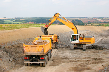 Motorway under Construction, Excavator and Dump trucks at Work