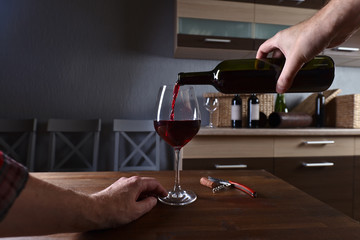 Sommelier pouring red wine into a glass
