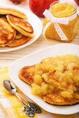 Pancakes with apple jam on white plate.