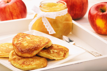 Pancakes with apple jam on white plate.