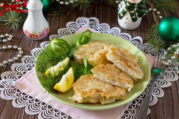 Fried fish in batter potato on a wooden Christmas table.