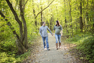 Fototapeta premium Beautiful pregnant couple relaxing outside in the park.
