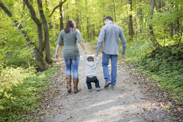 Happy pregnant family having fun in autumn nature