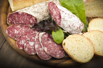 wooden cutting board with salami and bread