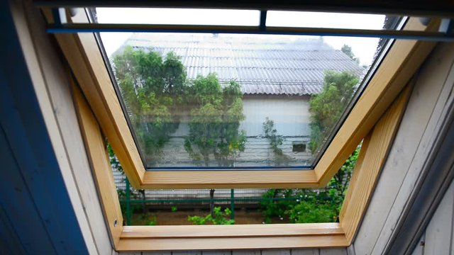 The attic window is open during the summer rain