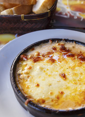 Baked traditional rustic Italian style lasagna in a clay pot..