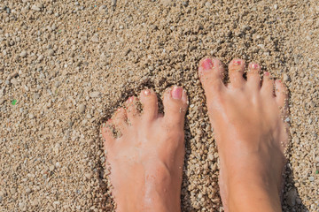 Female feet relaxing on the beach