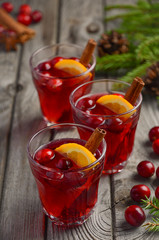 Cranberry drink on wooden background with fir branches and fresh berries, selective focus