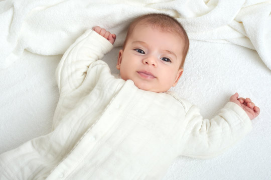 baby portait lie on white towel in bed