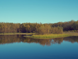 Fototapeta na wymiar Fall River, reflected in the water autumn trees.