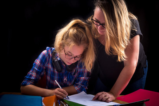 une m&egrave;re aide sa fille adolescente &agrave; faire ses devoirs