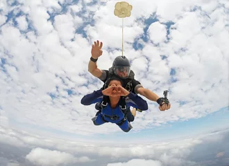 Tuinposter Skydiving tandem heart sign © Mauricio G