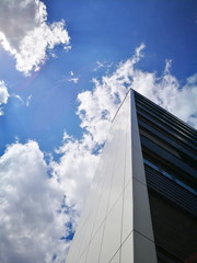 Fototapeta na wymiar Looking upwards on skyscraper with sky and clouds