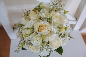 Gold rings on wedding bouquet with white roses