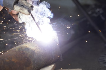 Iron welding with bright light and smoke at manufacturing