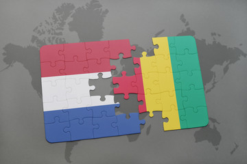 puzzle with the national flag of netherlands and guinea on a world map background.