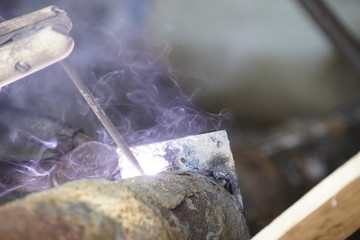 Iron welding with bright light and smoke at manufacturing