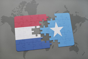 puzzle with the national flag of netherlands and somalia on a world map background.