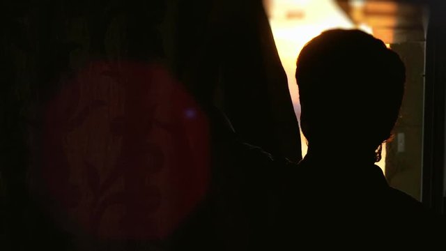 Man in dark room opens curtains on window to the sun and try to touches the sunshine in slowmotion. 1920x1080