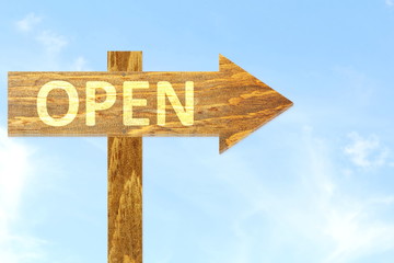 Open text on wooden arrow Sign in sky Background