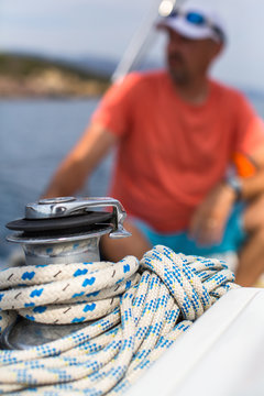 Rope on the yacht, a sailor is blurred in the background.