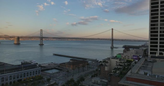 An evening sunset time lapse over the San Francisco Bay Bridge.	 	