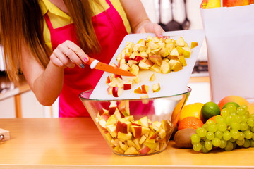 Woman housewife in kitchen cutting apple fruits