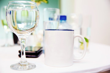 A cup of tea and a glass of wine on white table