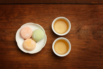 Colorful mochi rice cake on white plate and two porcelain cups w