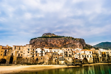 Fototapeta na wymiar View on habour and old houses in Cefalu at sunset, Sicily. Beautiful townscape of old italian town. Travel photography.