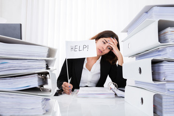 Unhappy Businesswoman Holding Help Flag In Office