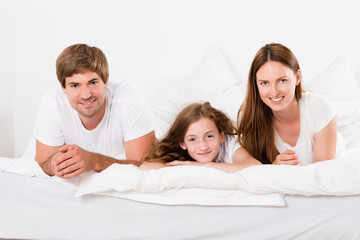 Smiling Family Lying On Bed