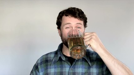 Model released man in studio guzzles entire beer and lets out a good burp and smile.