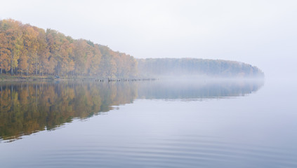 Fog on the lake Senezh in Solnechnogorsk fall in calm weather. Autumn water landscape