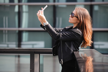 Young beautiful woman taking a selfie in the city