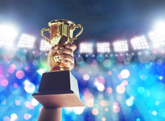 Man holding up a gold trophy cup,win concept.