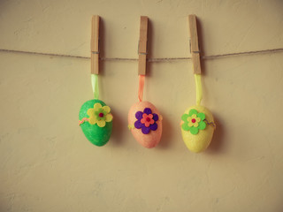 Decorated easter eggs dangling on the rope over concrete background
